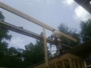 Carpenter setting a ridge beam over a new addition frame — Ice Dam Removal by Roofing Brothers in Pleasant Dale