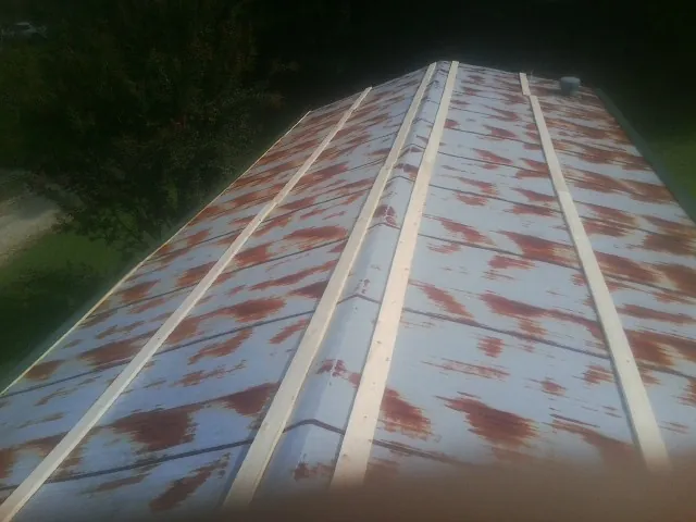 Rusted metal roof panels with new wood purlins before replacement — Storm Damage Roof Repair in Pleasant Dale by Roofing Brothers