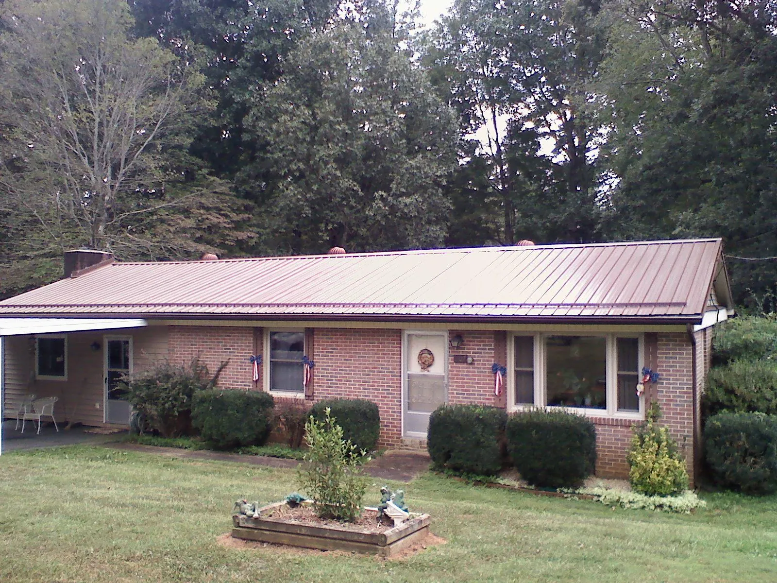 Bronze metal roof on a brick ranch home with a carport in Pleasant Dale