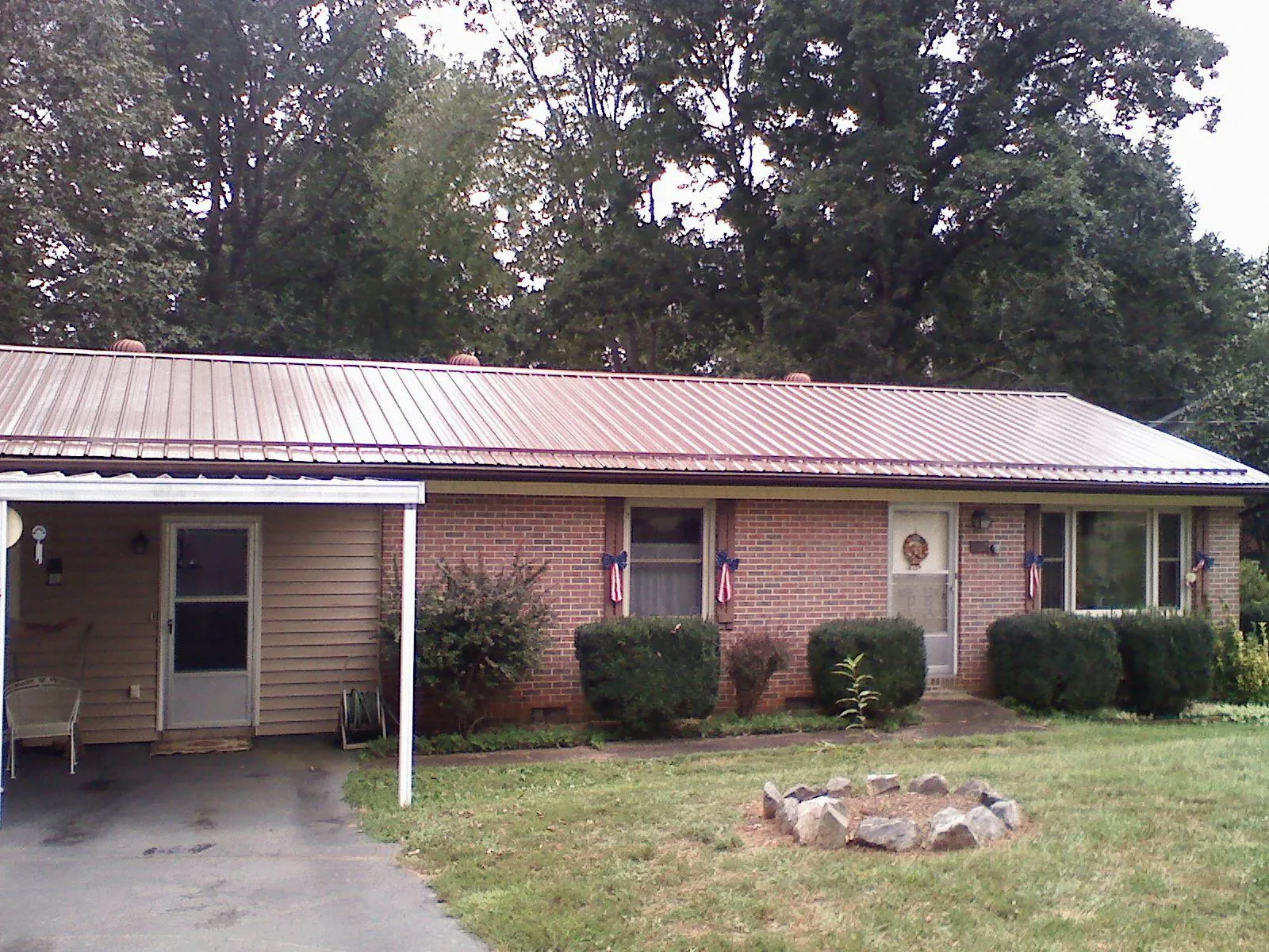 Bronze metal roof and carport on a brick ranch home — Roof Repair work by our crew in Pleasant Dale